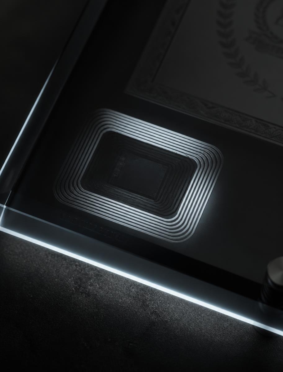 Macro view of an NFC antenna embedded beneath a smoked glass certificate plaque