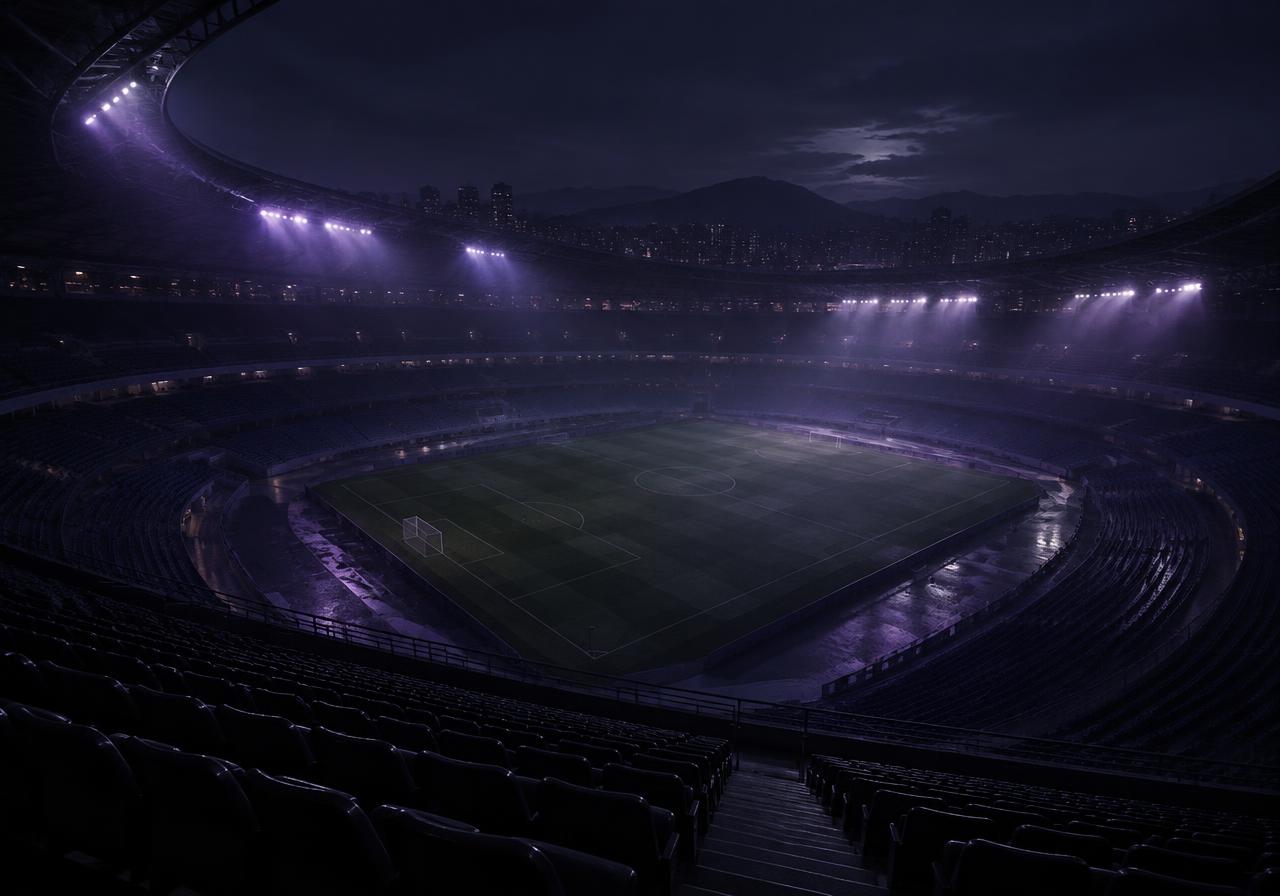 An empty floodlit stadium at night seen from high in the stands